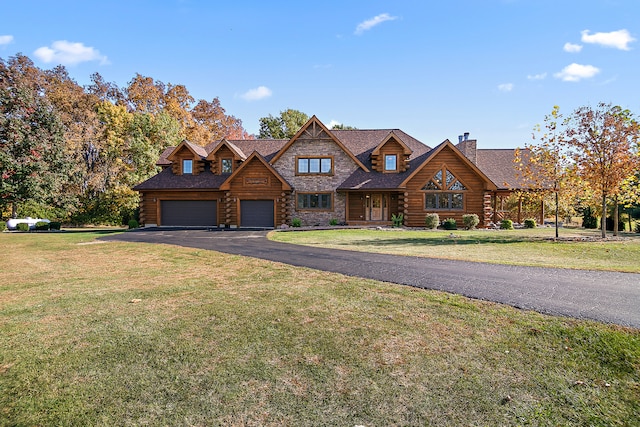 log-style house featuring a garage and a front lawn