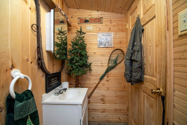 bathroom with vanity, wood ceiling, lofted ceiling, and wooden walls