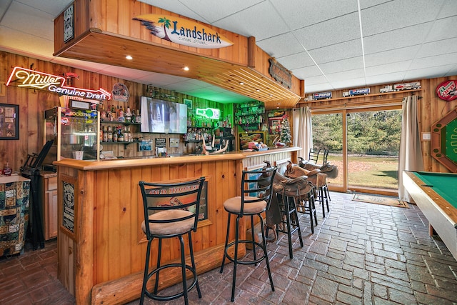 bar with wooden walls, a paneled ceiling, and billiards