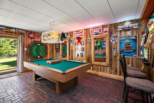 recreation room with pool table, a drop ceiling, and wooden walls