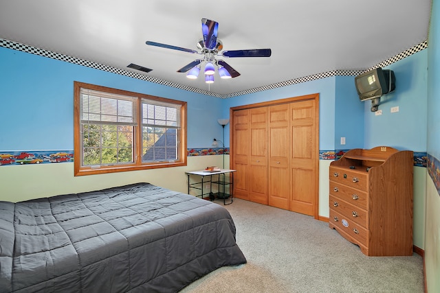 carpeted bedroom featuring a closet and ceiling fan