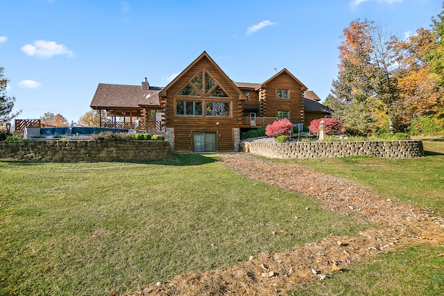 rear view of property featuring a yard and a balcony