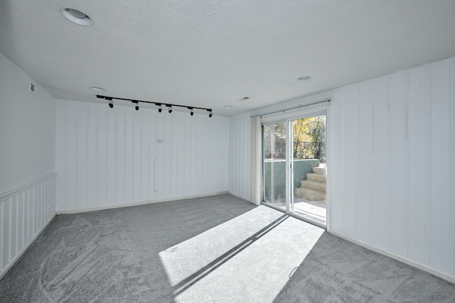 carpeted empty room with track lighting