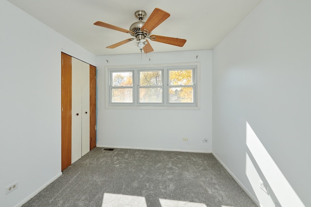 unfurnished bedroom featuring a closet, carpet, and ceiling fan