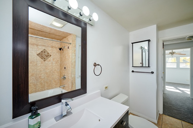 full bathroom with ceiling fan, toilet, vanity, tiled shower / bath combo, and tile patterned floors