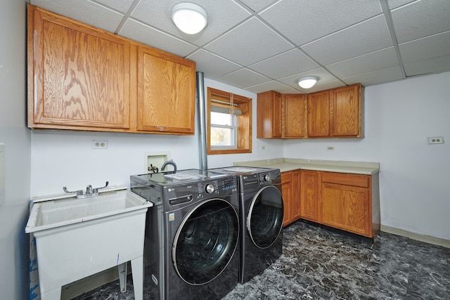 laundry area featuring sink, washing machine and dryer, and cabinets