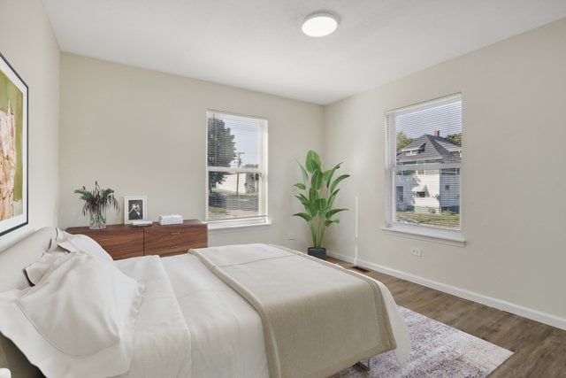 bedroom with multiple windows and dark hardwood / wood-style flooring