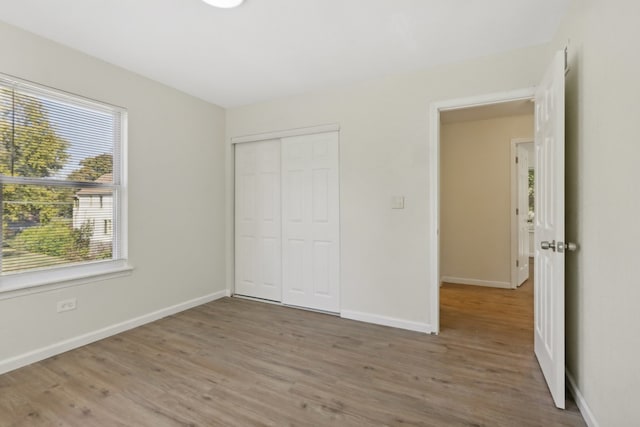 unfurnished bedroom featuring a closet and hardwood / wood-style floors