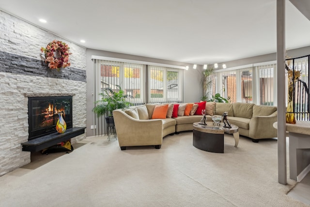 living room with a stone fireplace and carpet