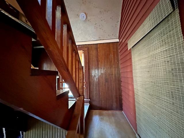 stairway featuring wood walls and wood-type flooring