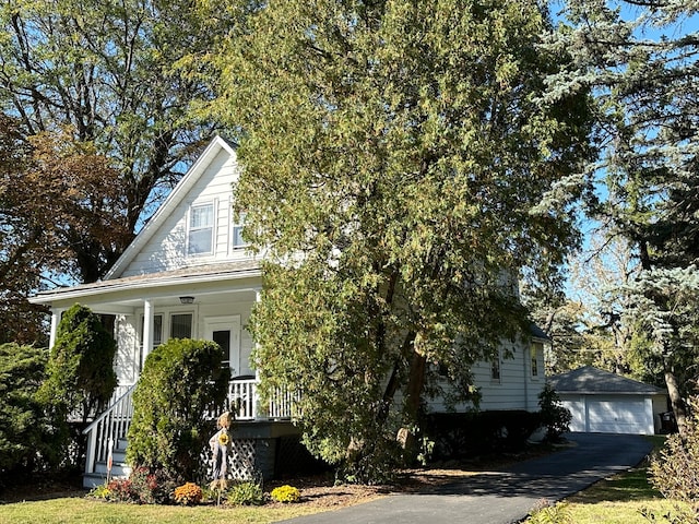 obstructed view of property with a porch, an outdoor structure, and a garage