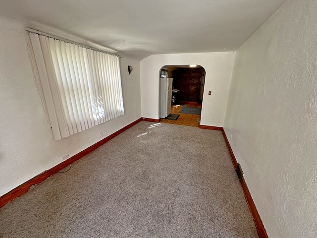 spare room with dark colored carpet