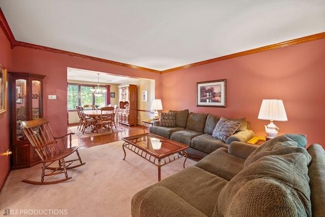 living room featuring light hardwood / wood-style floors, a notable chandelier, and ornamental molding