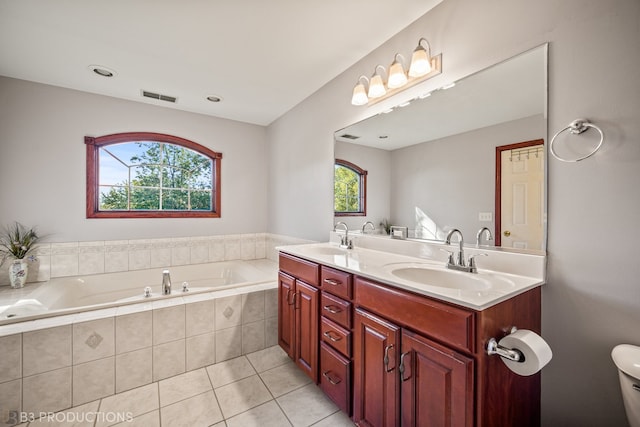 bathroom featuring vanity, a healthy amount of sunlight, tile patterned flooring, and tiled bath