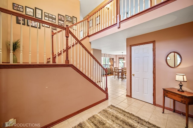 staircase with tile patterned floors and a high ceiling