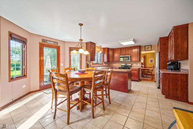 dining space with sink, light tile patterned flooring, and a chandelier