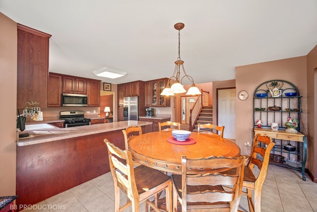 dining room with sink, light tile patterned flooring, and a notable chandelier