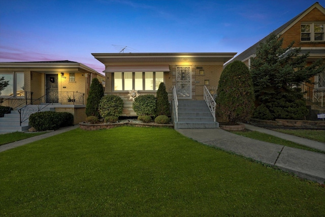 bungalow-style house with brick siding and a front yard