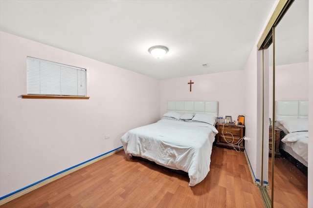 bedroom featuring wood finished floors and a closet