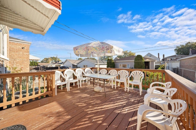 wooden terrace featuring a residential view and outdoor dining area