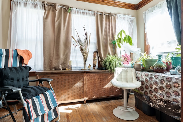 sitting room with ornamental molding and hardwood / wood-style floors