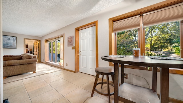 tiled dining area featuring a textured ceiling