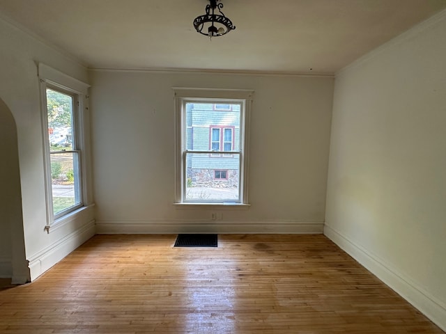 unfurnished room featuring ornamental molding and light hardwood / wood-style flooring