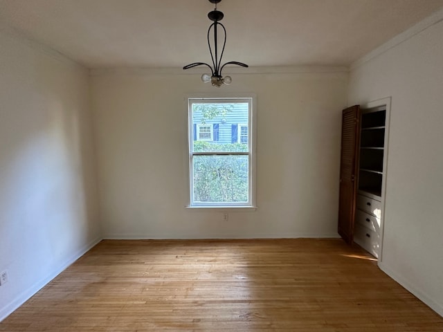 unfurnished dining area with ornamental molding, light hardwood / wood-style flooring, and an inviting chandelier