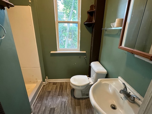 bathroom featuring toilet, hardwood / wood-style flooring, a shower, and sink