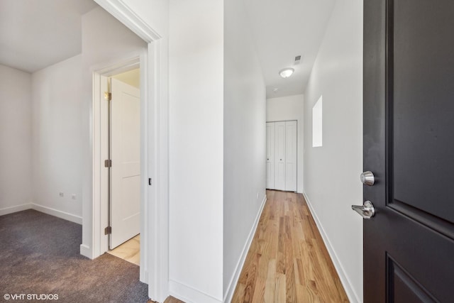 corridor featuring light wood-style floors, visible vents, and baseboards