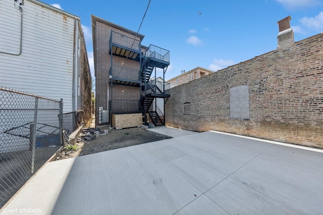 view of patio with stairway and fence