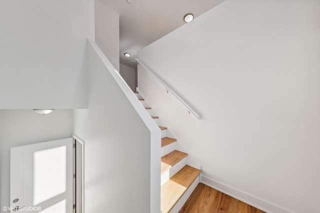 staircase with wood finished floors and baseboards