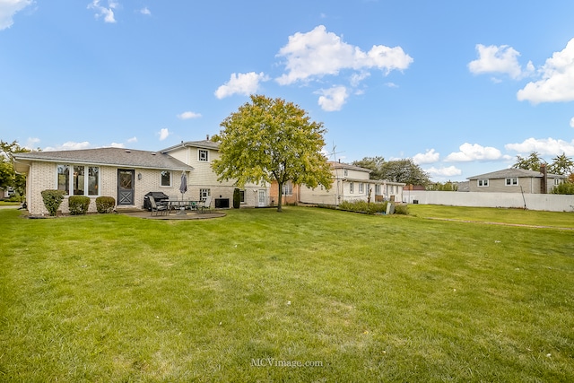 rear view of house featuring a patio and a lawn