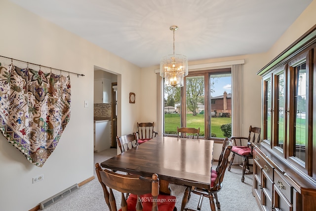 dining room featuring a chandelier and light colored carpet