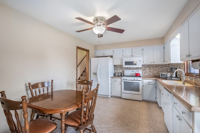 kitchen featuring white appliances, sink, light tile patterned flooring, white cabinetry, and decorative backsplash