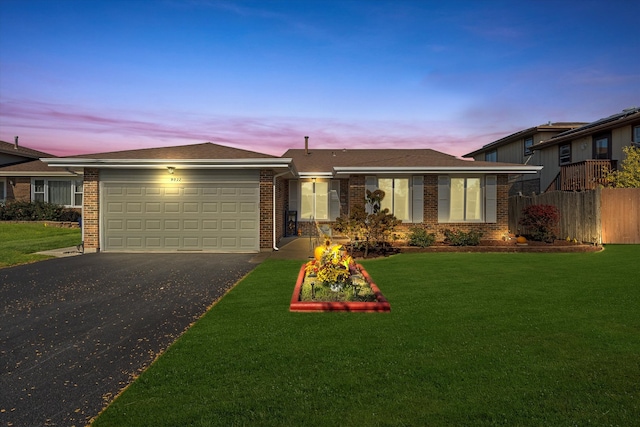 view of front of house featuring a garage and a lawn