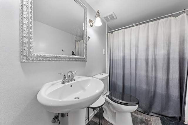 bathroom with lofted ceiling, a shower with curtain, and toilet