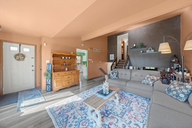 living room featuring lofted ceiling with beams and wood-type flooring