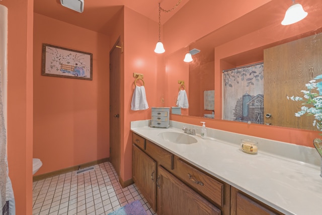 bathroom with vanity, toilet, and tile patterned floors