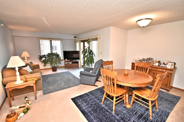 carpeted dining room with a textured ceiling