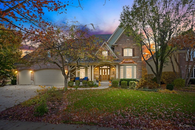 view of front of house featuring a garage and a lawn