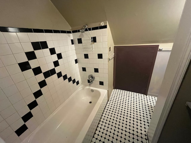 bathroom with tiled shower / bath combo and tile patterned flooring