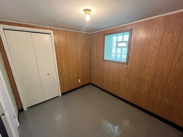 unfurnished bedroom featuring a closet and wood walls