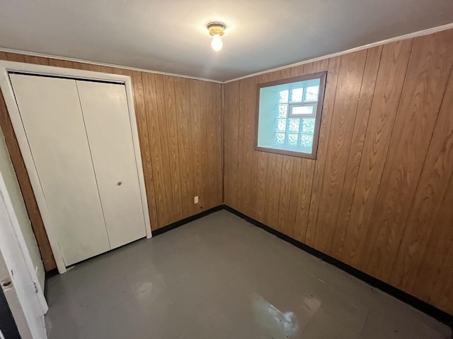 6916 S Lowe Ave, Chicago, IL 60621 - unfurnished bedroom with wooden walls, a closet, and finished concrete floors