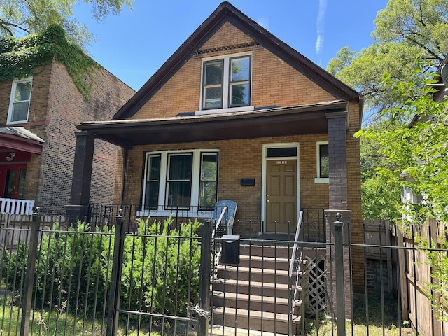 6916 S Lowe Ave, Chicago, IL 60621 - bungalow featuring a gate, a fenced front yard, a porch, and brick siding