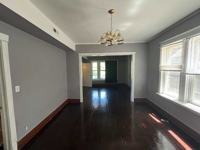 unfurnished dining area with crown molding, dark hardwood / wood-style flooring, and a chandelier