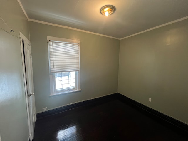 unfurnished room featuring ornamental molding and dark hardwood / wood-style flooring