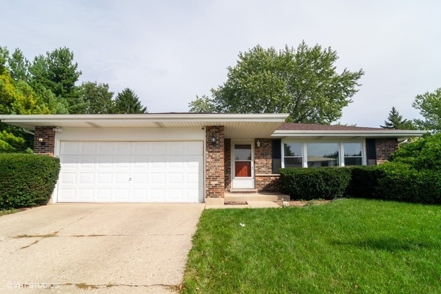 single story home featuring a front yard and a garage