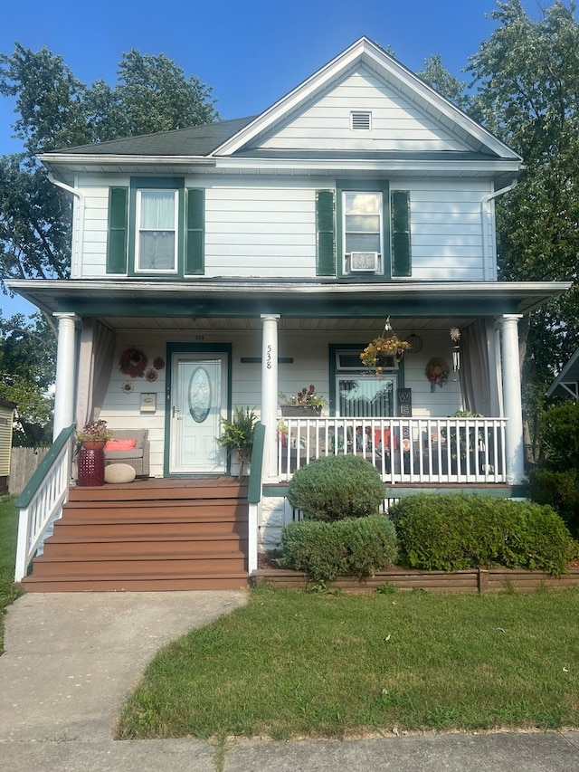 view of front facade with a porch, cooling unit, and a front yard