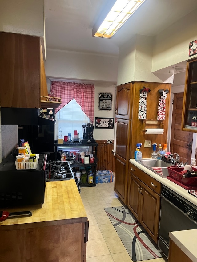 kitchen with black dishwasher, sink, and light tile patterned floors